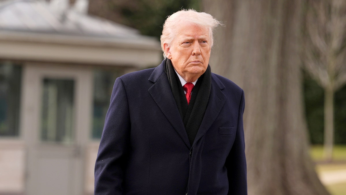 A U.S. president walks across the White House lawn toward a helicopter for departure.