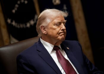 President Donald Trump looking down during a meeting at the White House.