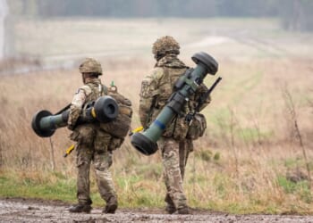 Two British soldiers carrying missile launchers.