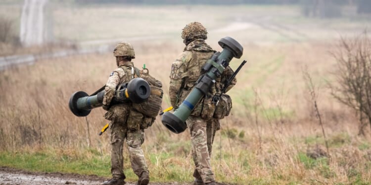 Two British soldiers carrying missile launchers.