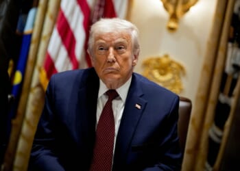 Trump in front of an American flag.