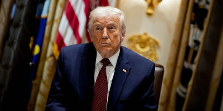 Trump in front of an American flag.