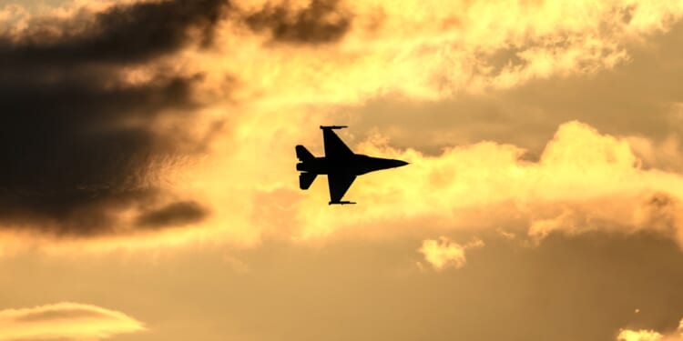 An F-16 in flight at dusk.