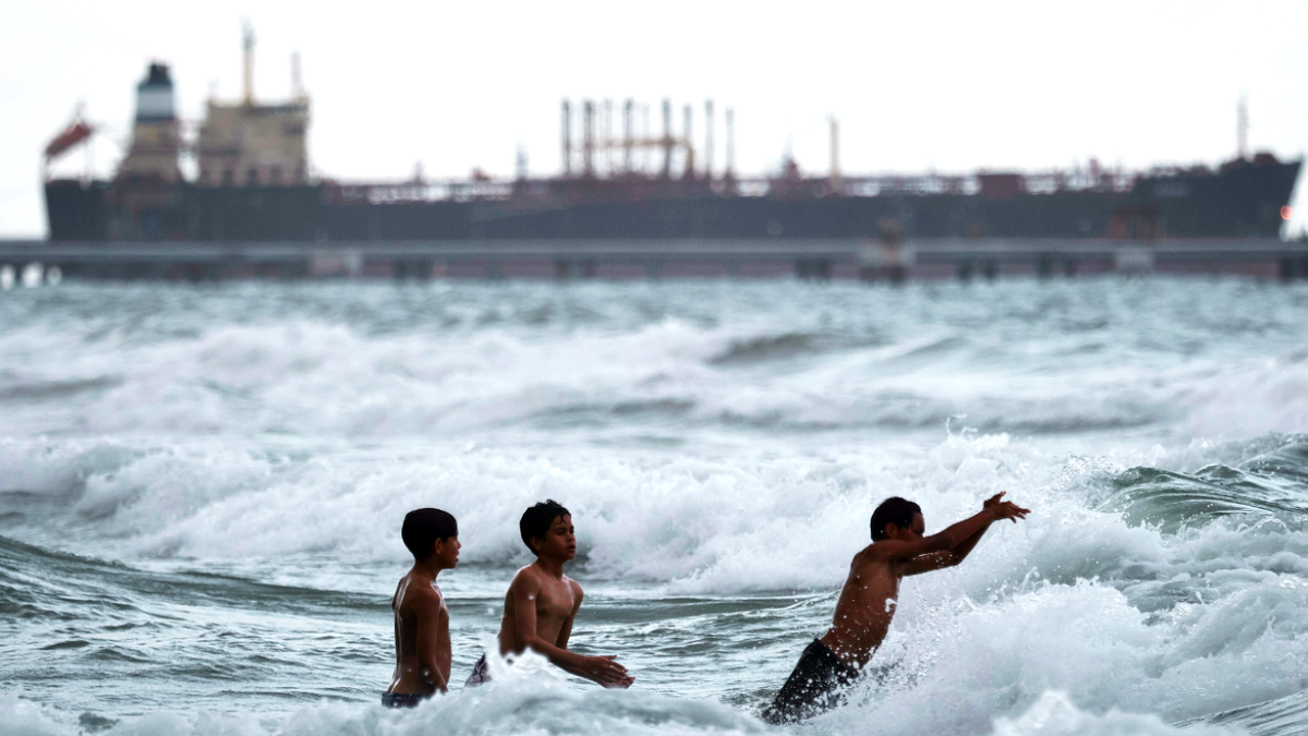 Venezuelan children bathing near an oil tanker docked at a pier near the refinery of the state oil company PDVSA.