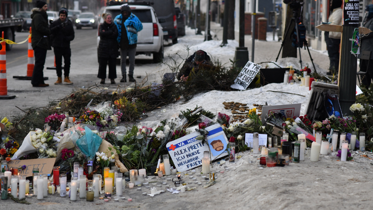 Flowers and candles are seen at the location of Alex Pretti's death in Minneapolis, Minnesota, on January 25, 2026.