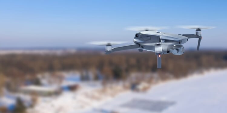 A drone flying over a snowy landscape.