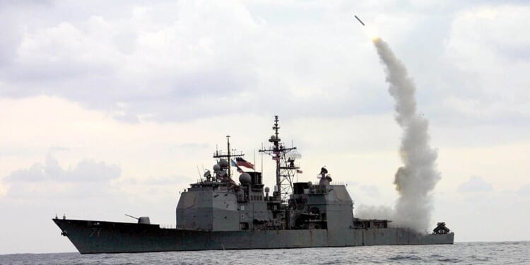 A Navy ship firing a missile.