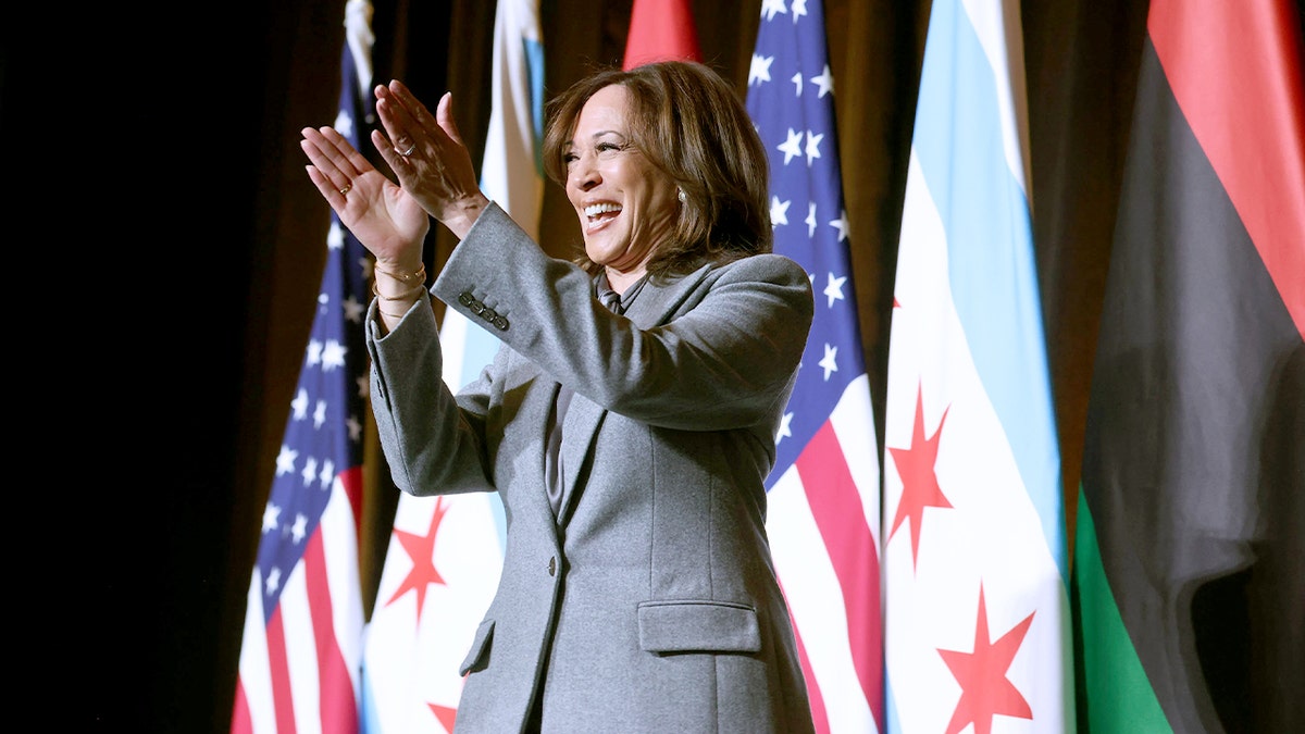 Kamala Harris walks through a hotel ballroom toward a stage as attendees look on.