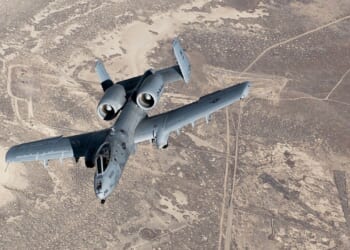 An A-10 Warthog in flight over a desert.