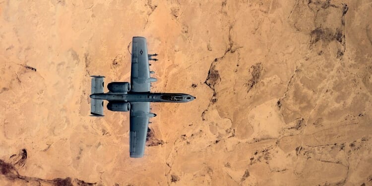 An A-10 Warthog flying over the desert.