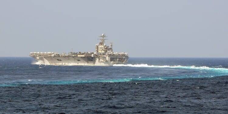 The USS Abraham Lincoln completes a turn in the ocean.