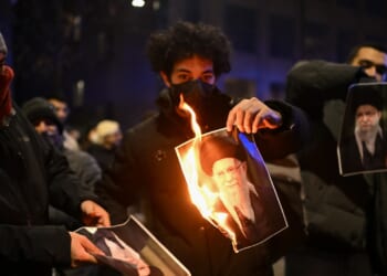 Several protesters burning pictures of Ayatollah Ali Khamenei.