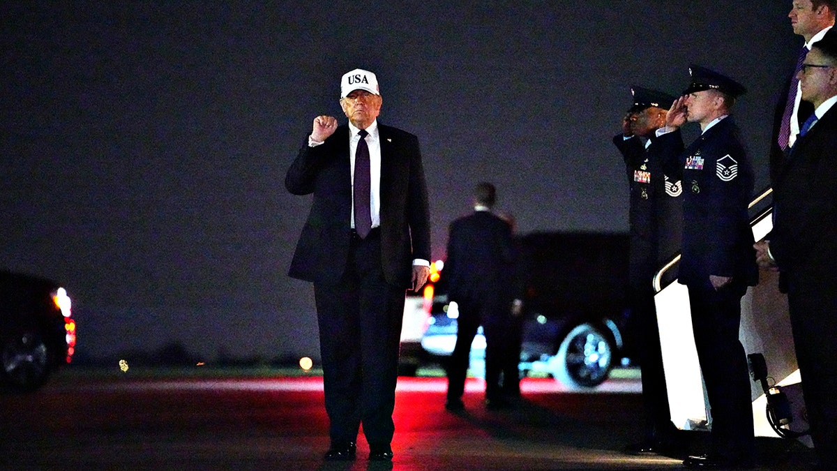 Donald Trump walking in white hat
