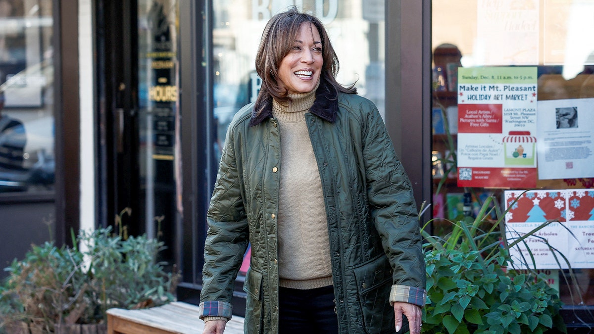A woman smiles while standing outside a small bookstore.