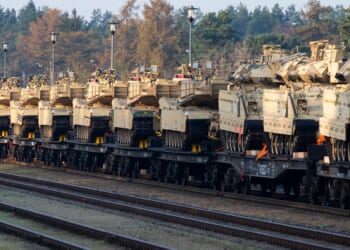 A group of Abrams tanks on a train.