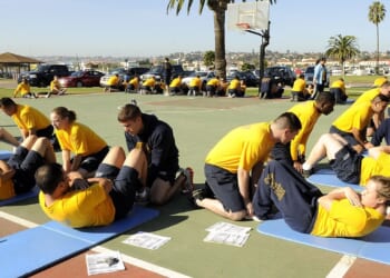 A group of Navy sailors doing sit-ups.