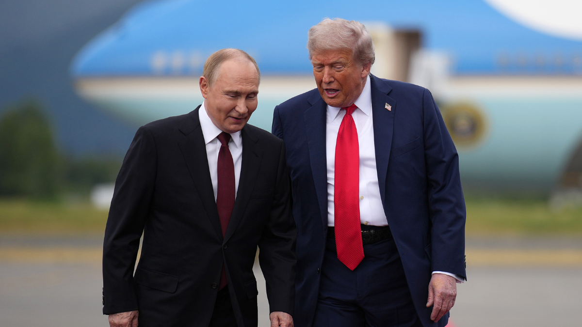 President Donald Trump walks next to Russian President Vladimir Putin in Alaska