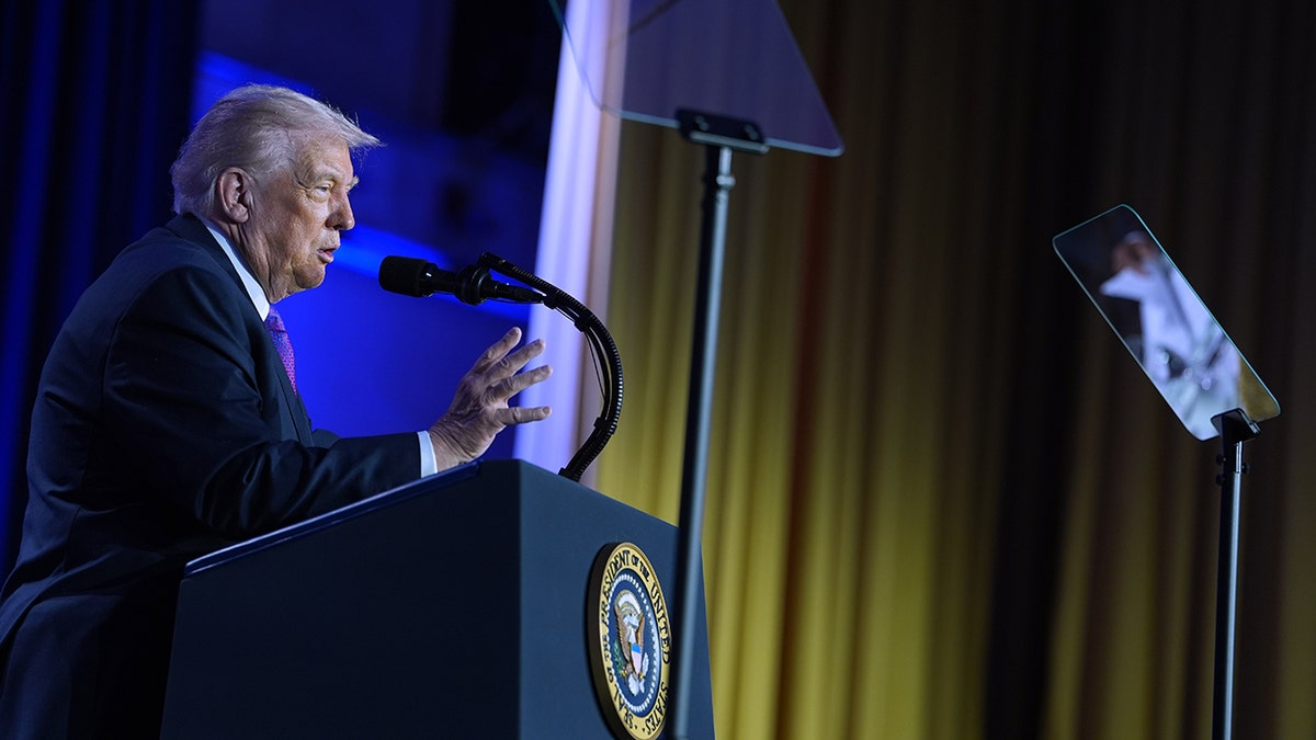 President Donald Trump speaking into a microphone while standing at a podium during an event.