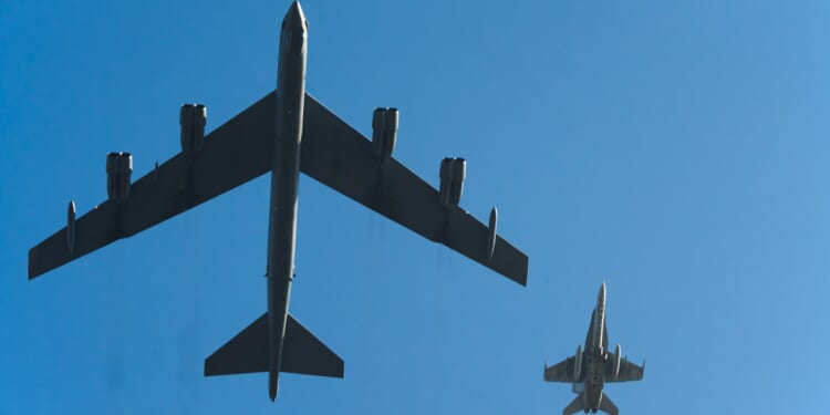 A B-52 Stratofortress and an F-16 Fighting Falcon flying next to each other.