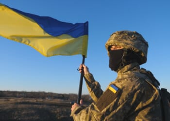 A Ukrainian soldier carrying a flag.