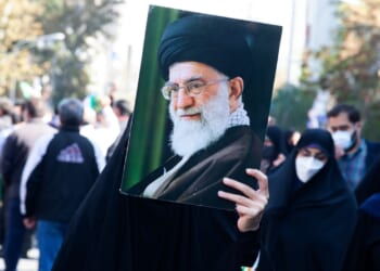 Woman holding a portrait of Iranian Supreme Leader Ali Khamenei.
