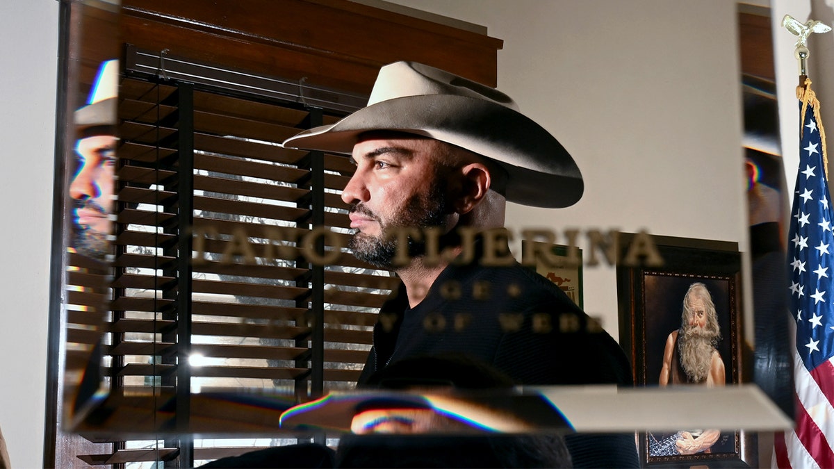 A county judge standing in his office during a formal portrait session.