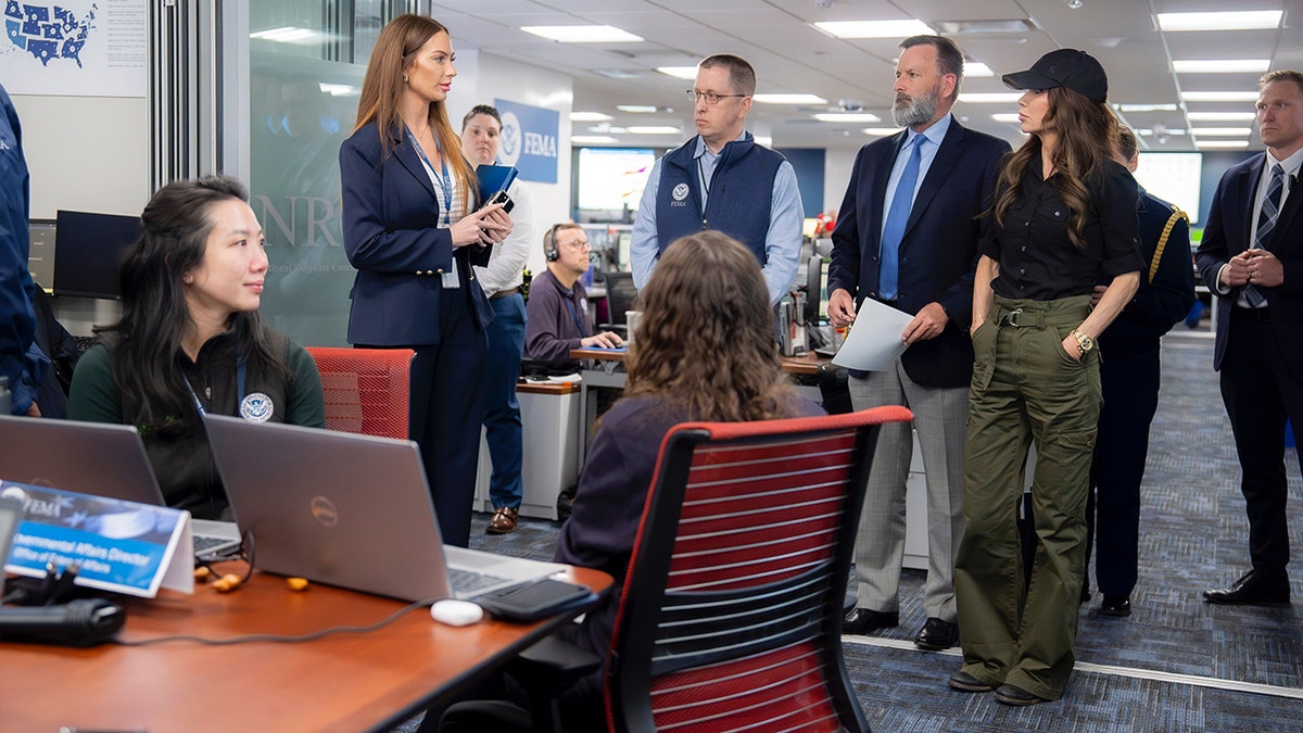 Homeland Security Secretary Kristi Noem listens at FEMA facility