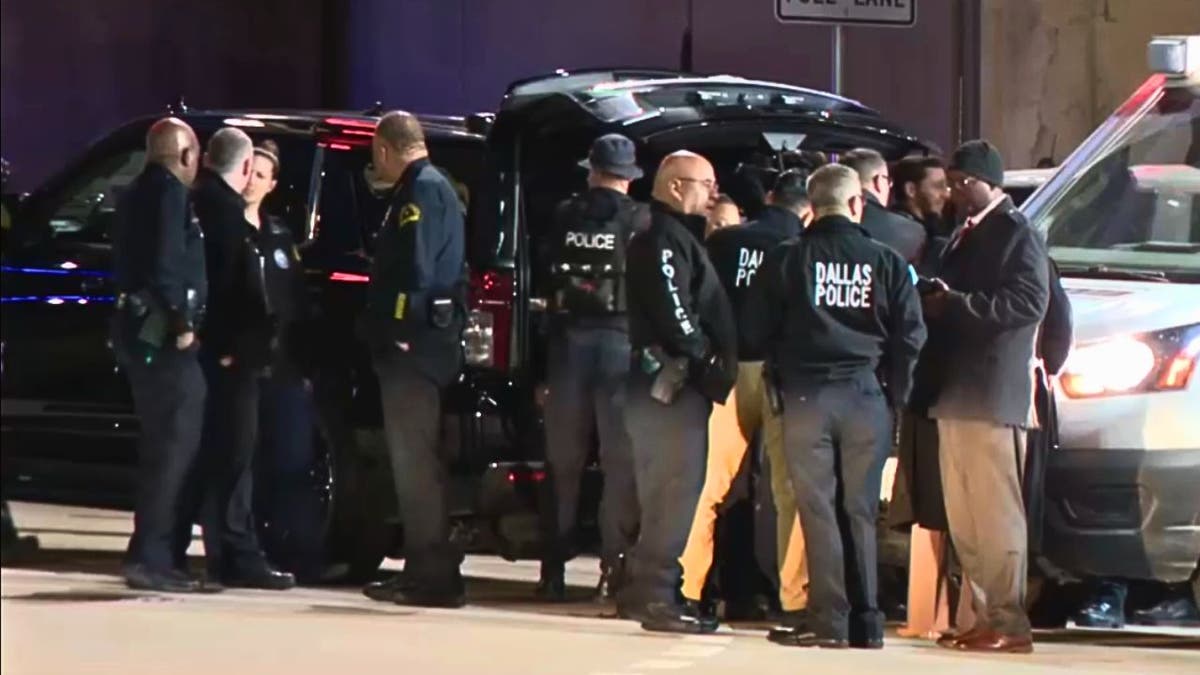 Dallas police officers standing near vehicles during response to hospital parking garage standoff