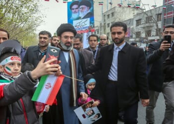 Mojtaba Khamenei walking with his children in a parade.
