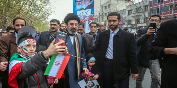 Mojtaba Khamenei walking with his children in a parade.