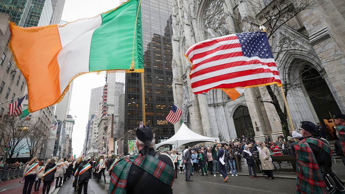 Marchers carry Irish and American flags along Fifth Avenue during a St. Patrick’s Day parade in New York City.