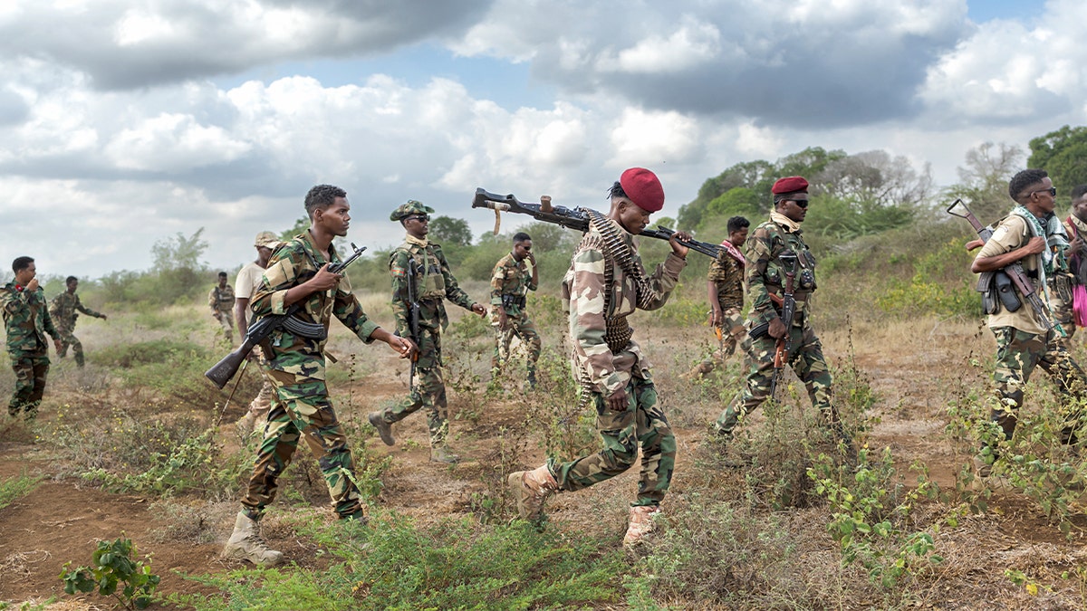 Somalia National Army soldiers patrol near a recently contested frontline area in the lower-Shabelle region.