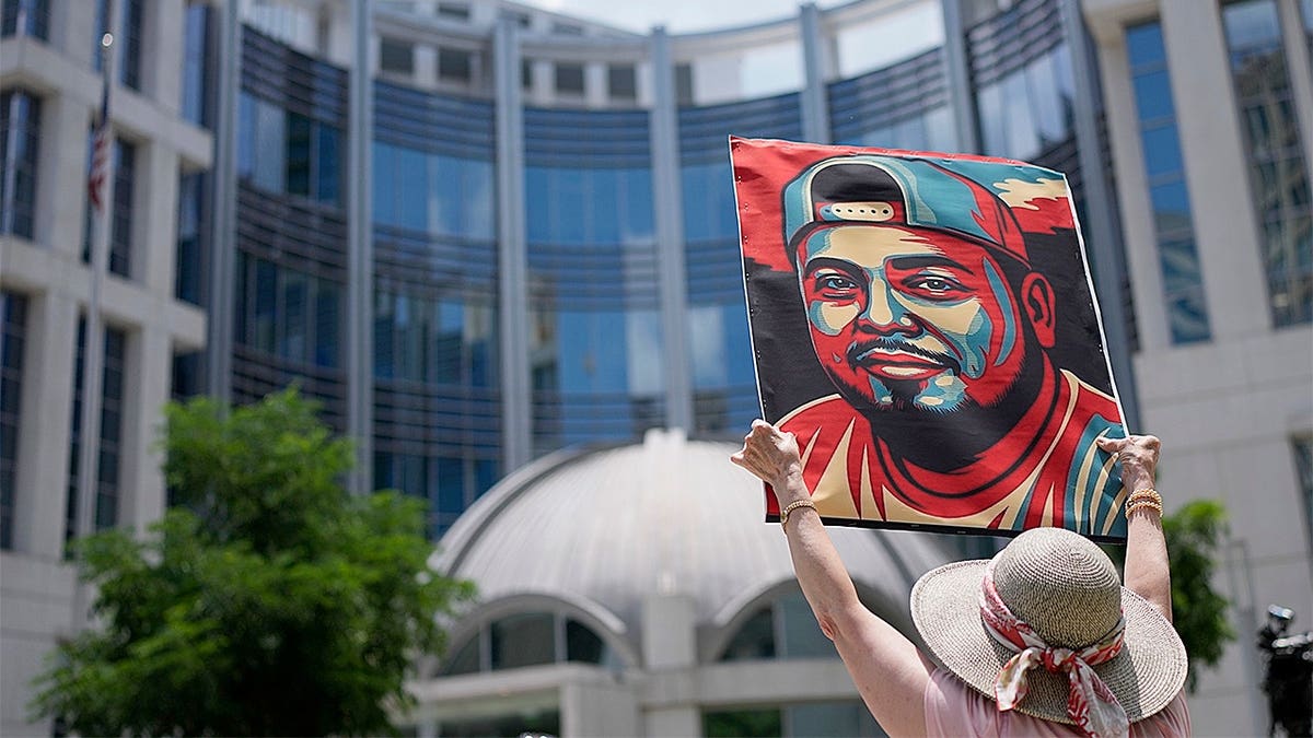 A woman is seen holding a sign of Kilmar Abrego Garcia in front of the U.S. Court for the Middle District of Tennessee. Abrego Garcia was deported to El Salvador's CECOT prison earlier this year, in what Trump administration officials described as an 'administrative error.' Photo via Getty Images