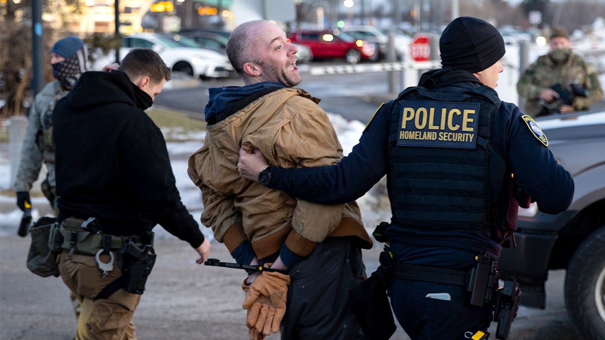 Federal agents arrest a protester outside an Immigration and Customs Enforcement facility in Minneapolis