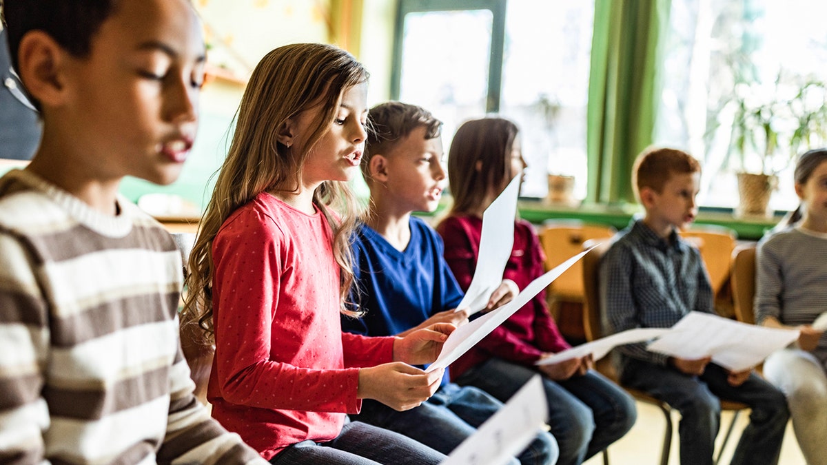 Children sing in a classroom.