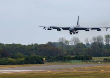 A B-52 Stratofortress descending to land on a runway.
