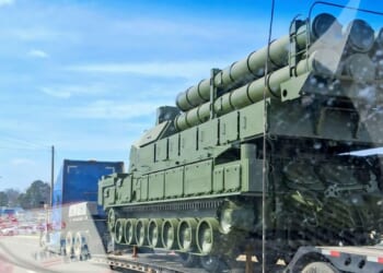 A mockup of a Russian anti-air missile system on the back of a flatbed truck on a highway.