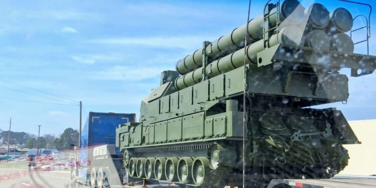 A mockup of a Russian anti-air missile system on the back of a flatbed truck on a highway.