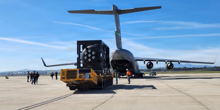 A small nuclear reactor being loaded onto a C-17 cargo plane.