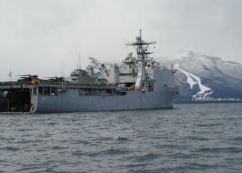The USS Tortuga seen on a foggy day near a mountain.