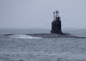 A US Navy submarine at sea on a rainy day.