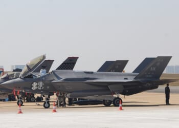 A row of F-35s on display on the tarmac at an airshow.