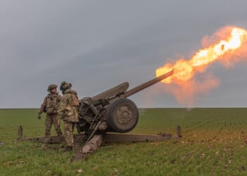 Three Ukrainian soldiers firing a cannon.