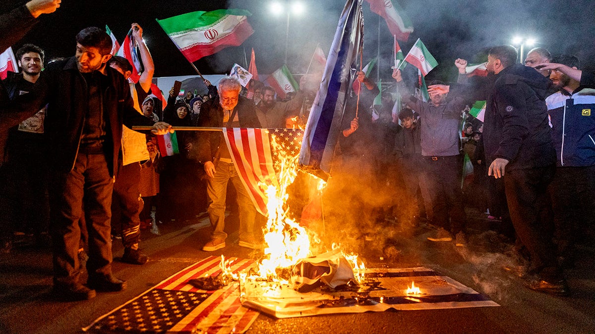 Iranians burning United States and Israel flags at Enghelab Square in Tehran