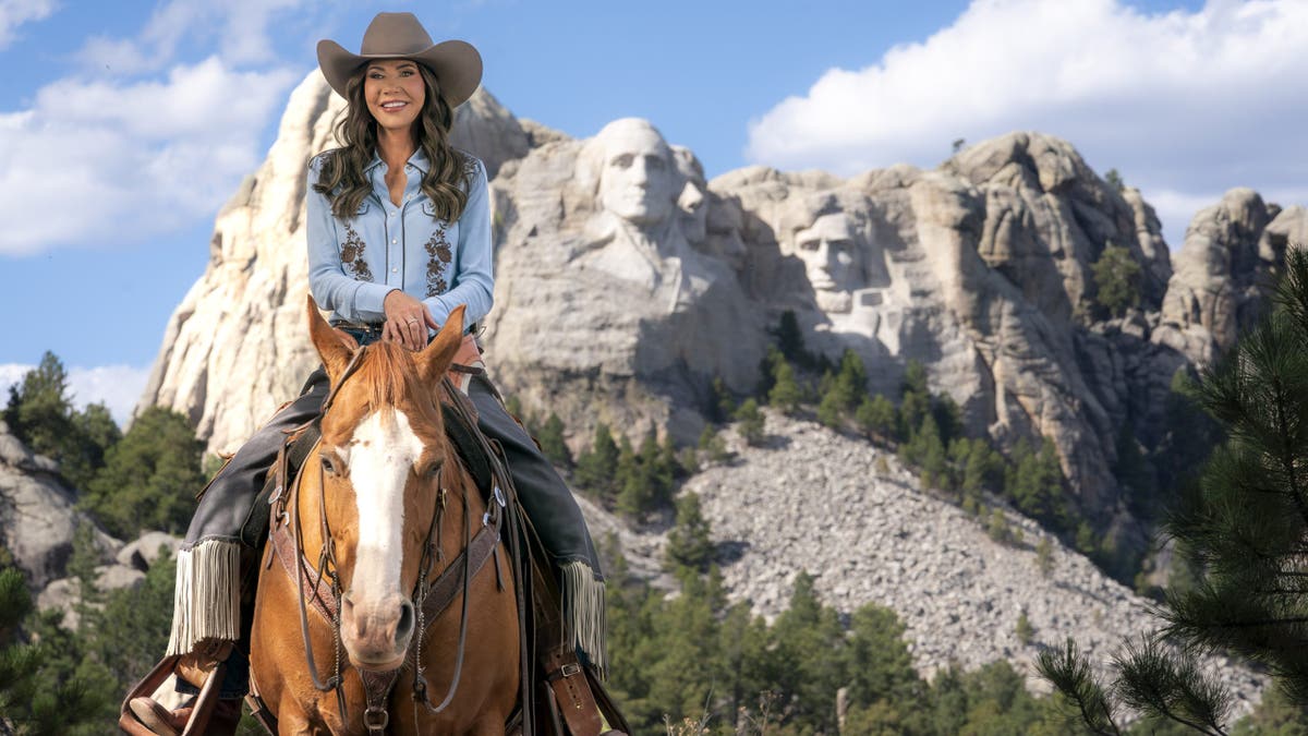 Secretary of Homeland Security Kristi Noem rides a horse while filming an ad at Mount Rushmore National Memorial.