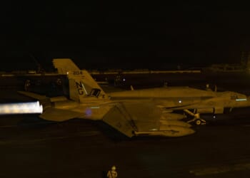 An F/A-18 Super Hornet taking off from the deck of an aircraft carrier.