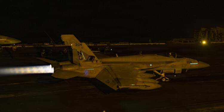 An F/A-18 Super Hornet taking off from the deck of an aircraft carrier.
