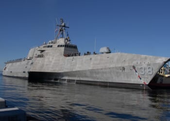 A Littoral Combat Ship at sea near a port.