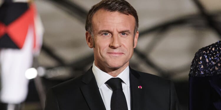 Emmanuel Macron at a black tie dinner, looking forward.