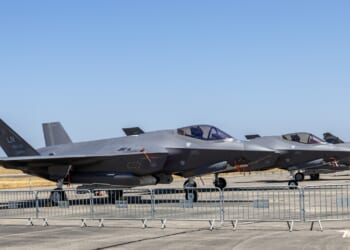 Several F-35s on display at an airfield.